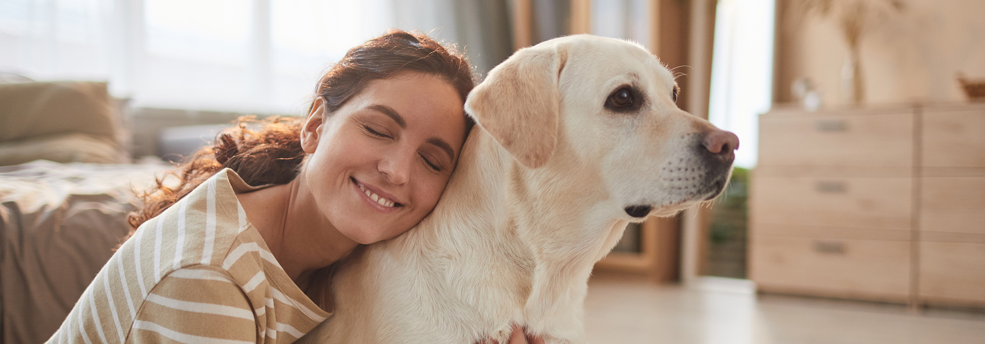 Een vrouw knuffelt haar grote labrador